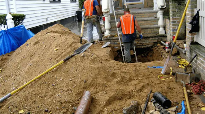 Contractors performing foundation protection and exterior drainage excavation near residential home steps in Stockton, CA